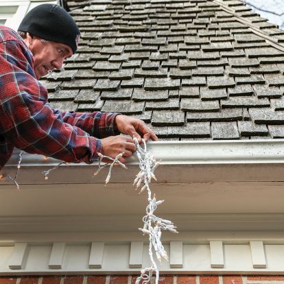 man hanging Christmas lights