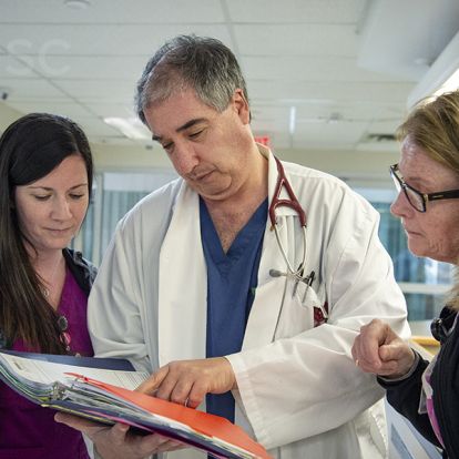 Dr. Baranchuk (centre) reviews the tool with nurses in KHSC's cardiac sciences unit